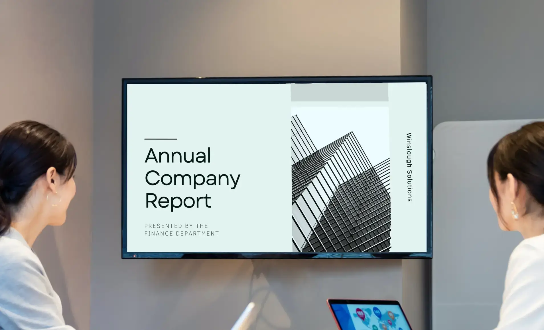 meeting room digital signage displaying annual company report presentation from Google Slides app