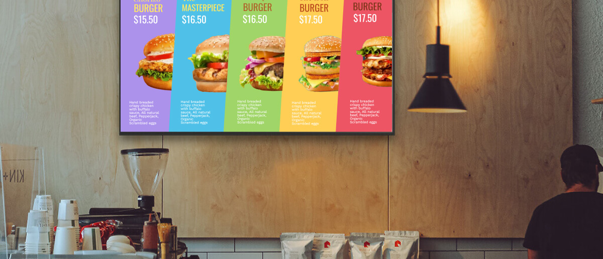 A TV menu board shows colorful burger images in a QSR takeaway counter