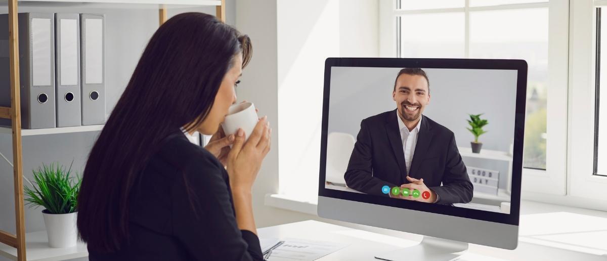 office employee interacting with client on a computer screen using video conferencing software