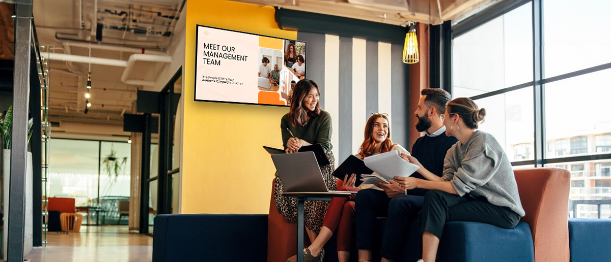 Team discussing workplace automation in a modern office with a digital display